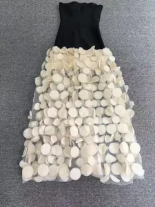 Détail d'une robe de soirée bustier noire avec jupe longue ornée de pétales 3D