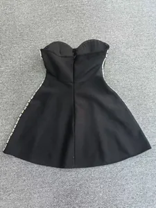 Close-up detail of side rhinestone embroidery on black strapless bandage party dress