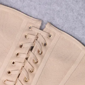 Close-up detail of apricot bandage dress featuring elegant gold eyelets and lace-up design