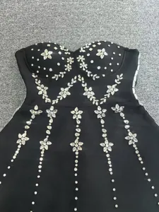 Close-up detail of heavy rhinestone floral patterns on black bandage dress