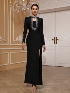 Elegant black long-sleeved bandage evening gown with heavy silver beading and high slit.