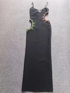 Detalle del vestido bandage negro con adornos de piedras preciosas rojas y verdes