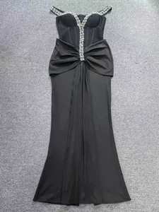 Dettaglio di elegante abito da sera nero con decorazioni in strass e spalline scoperte
