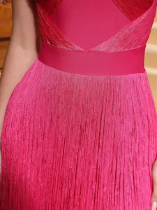 High-quality close-up detail of a magenta bandage dress featuring layered fringe tassels.