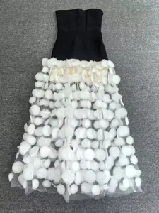 Détail d'une robe de soirée bustier noire avec un ourlet de jupe à pétales 3D.