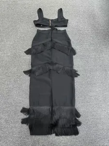 Detailed view of black two-piece bandage dress with tiered fringe and back zipper.