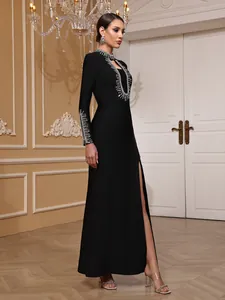 Side view of elegant black bandage evening gown with silver rhinestone detail and high slit