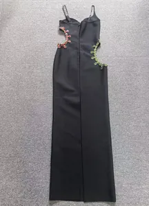 Detalle trasero de vestido de noche negro con adorni de pedrería asimétrica roja y verde