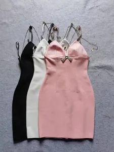 Detailweergave van elegante bandagejurken in roze wit en zwart met strass-bandjes.