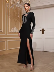 Elegant black long sleeve evening gown featuring heavy beadwork details and a high leg slit