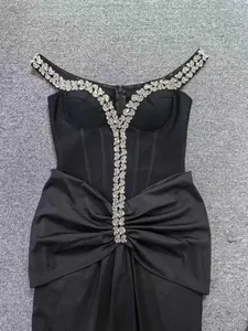 Dettaglio di un abito da sera nero con spalle scoperte e rifiniture in strass luccicanti