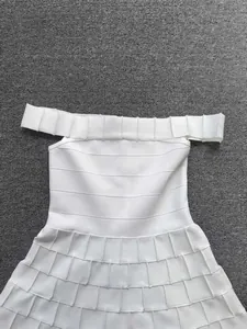 Close-up of white off-the-shoulder bandage dress showing textured pleated details