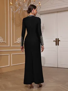 Back view of elegant black long-sleeved evening gown with silver beadwork detailing