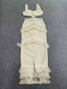 Close-up showing the intricate layered tassel fringe on this beige bandage knit cutout dress