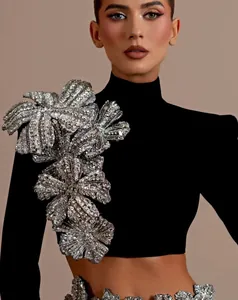 Close-up detail of black bandage crop top featuring intricate rhinestone floral applique.