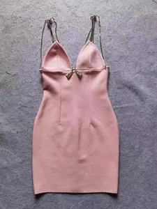 Close-up van roze bodycon partyjurk met glanzende strass kettingbandjes en strikdetail