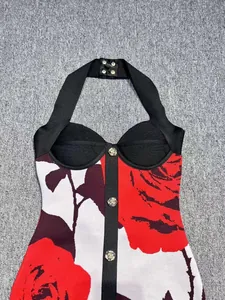 Detail of halter neck bandage dress with vibrant red rose print and decorative buttons