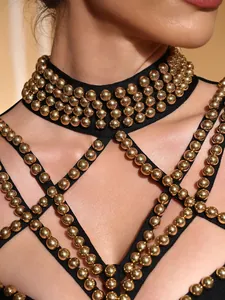 Primer plano detallado de los adornos de cuentas doradas en el vestido de fiesta negro