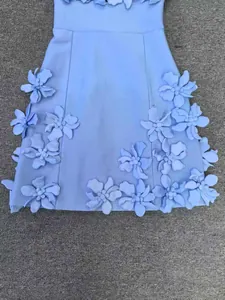 Détail rapproché de la robe bandage bleu clair avec des fleurs en 3D complexes