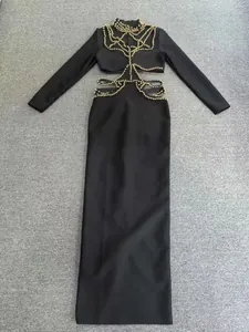 Detalle de elegante vestido largo bandage negro con abalorios dorados y recortes en cintura