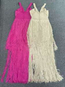Detail view of fuchsia and beige deep V-neck bandage dresses with floor-length tassels.