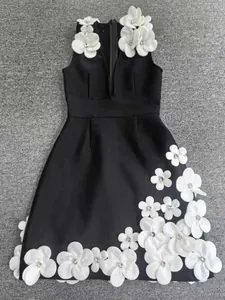 Detailed shot of heavy 3D flower embellishments on black sleeveless V-neck dress