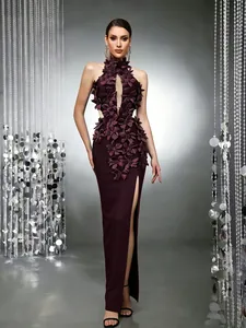 Close-up of deep plum long evening gown featuring intricate 3D floral appliqués and leg slit.