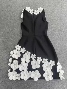 Close-up of elegant black bandage dress with 3D white flower appliqués and beads