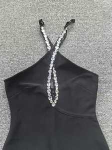 Gros plan d'une robe bandage noire à licou élégante avec des bretelles en strass