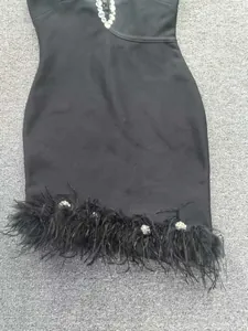 Vue détaillée d'une robe bandage noire avec bordure en plumes et strass brillants