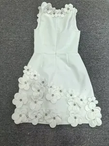 Detailed view of 3D floral appliqués and beadwork on white sleeveless bandage dress
