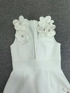 Detailed view of exquisite 3D handmade flowers and crystal beadwork on white bandage dress