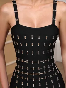 Detalle de vestido bandage negro con pedrería brillante y aberturas decorativas.
