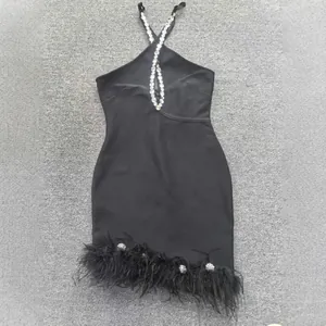Robe bandage noire à licou avec strass étincelants et ourlet en plumes délicates.
