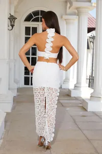 Detailed back view of white lace hollow-out bandage dress featuring elegant ruffle trim