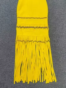 Detailed view of yellow bandage evening dress with elegant long fringe and beadwork