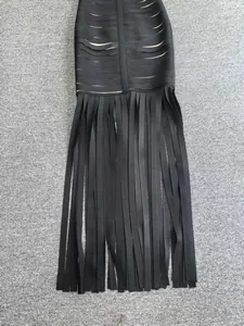 Detailed view of a black bandage evening dress featuring long hanging fringe tassels