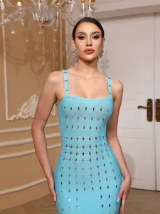 Detalle de un vestido bandage azul con elegantes adornos de tachuelas plateadas.
