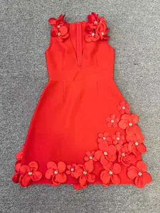 Macro detail of red bandage dress featuring 3D floral appliqués and sparkling beadwork