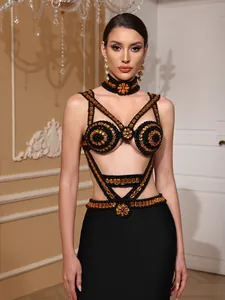 Detailed view of a black bandage evening dress with intricate amber beaded embellishments.