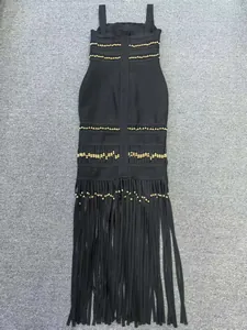 Detailed view of a black bandage dress featuring gold bead accents and long fringe tassels.
