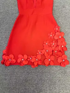 Detail of red bandage dress with 3D floral appliqués and rhinestone centers
