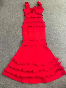 Détail d'une robe de soirée sirène rouge avec volants et détail floral au col carré