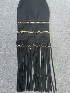 Close-up detail of the decorative gold beads and long black tassels on this bandage dress