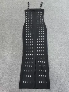 Detalle de un vestido bandage negro ajustado con brillantes adornos verticales de pedrería.