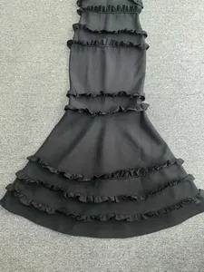 Détail des volants superposés sur une robe de soirée noire de style bandage sirène