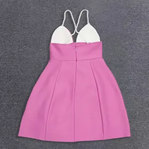 Detailed back view of a pink A-line bandage dress featuring pearl crossover straps.