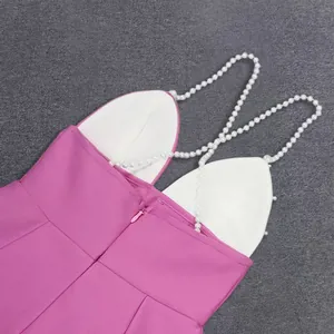 Close-up detail of a pink bandage dress featuring pearl straps and hidden back zipper