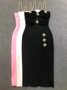 Detailansicht von strassverzierten Verbandskleidern mit eleganten Goldkettenträgern.