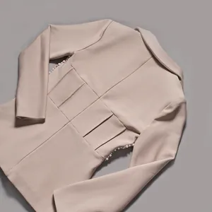 Dettaglio del blazer beige da donna con perline laterali e vita molto strutturata